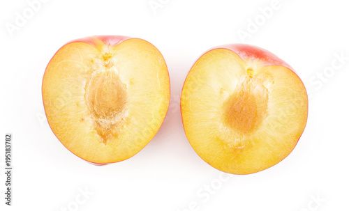 Plums red orange two sliced halves top view isolated on white background.