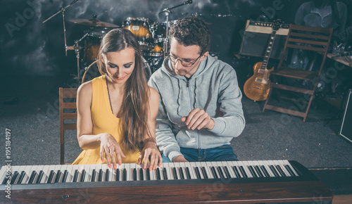 Foto Piano teacher giving lessons to his student in music school