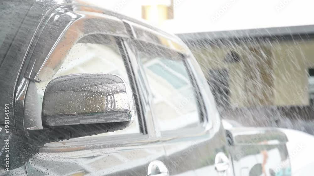 Sprinkle water on the car with a spray before cleaning the car with a car wash in the car care center. Sprinkle water on the car with a spray before cleaning the car with a car wash in the car care center.