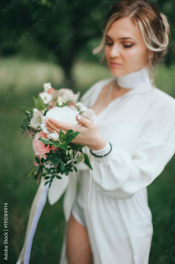 stylish wedding bride with bouquet and amazing modern dress. bride posing and smiling in sunny garden stylish wedding bride with bouquet and amazing modern dress. bride posing and smiling in sunny garden