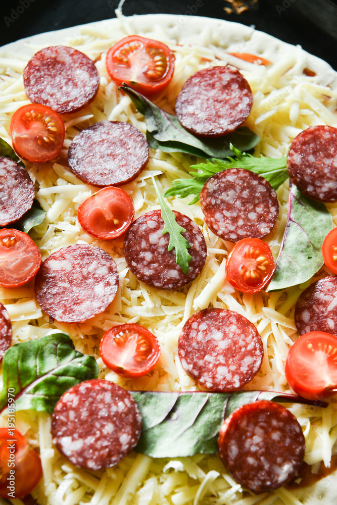 Ingredients for Pizza: basis dough, salami sausage, cherry tomatoes, grated cheese, tomato paste, herbs and arugula. Natural Wooden Background With Linen Napkin and Knife For Pizza Ingredients for Pizza: basis dough, salami sausage, cherry tomatoes, grated cheese, tomato paste, herbs and arugula. Natural Wooden Background With Linen Napkin and Knife For Pizza