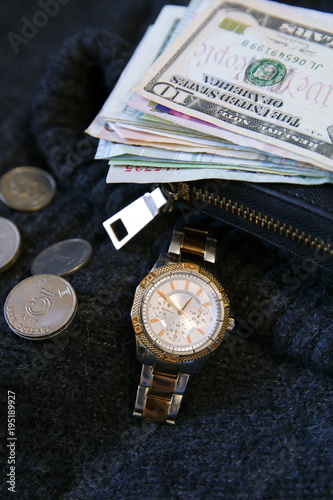 Women's watch, wallet and money cash and coin is on wool. Dollars, yuan, Hong Kong dollars, baht, Lira