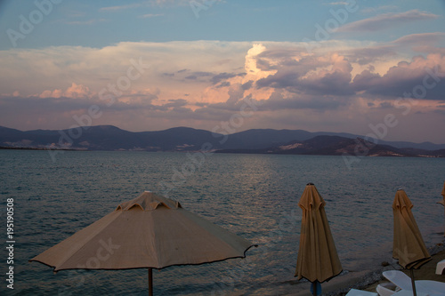 The end of the tourist season on the coast of the Aegean Sea near the Turkish city of Didim. A beautiful view of the sunset over the mountains located by the sea.