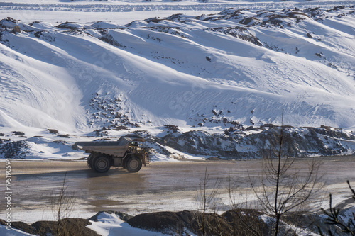Haul truck driving through an open pit mine in winter
