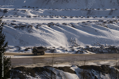 Large haul truck carrying ore across an open pit mine