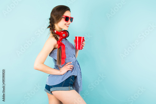 Young sexy woman with headphones and cup