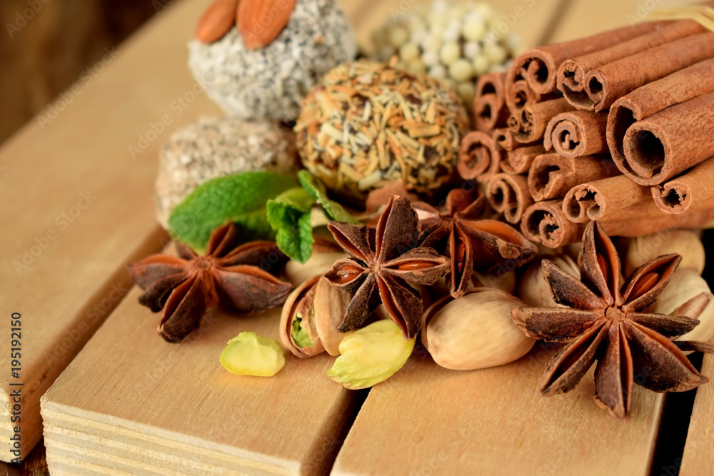 Sweets with different sprinkles, cinnamon, anise stars, mint and pistachio nuts on wooden boards Sweets with different sprinkles, cinnamon, anise stars, mint and pistachio nuts on wooden boards