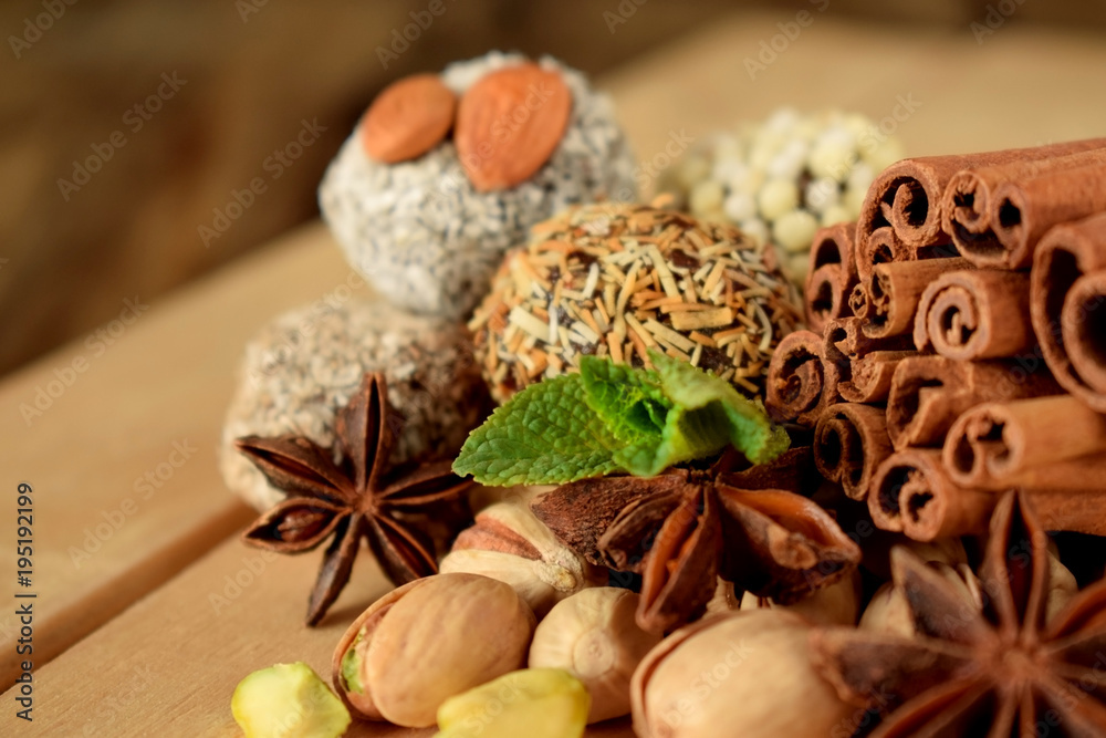 Sweets with different sprinkles, cinnamon, anise stars, mint and pistachio nuts on wooden boards Sweets with different sprinkles, cinnamon, anise stars, mint and pistachio nuts on wooden boards