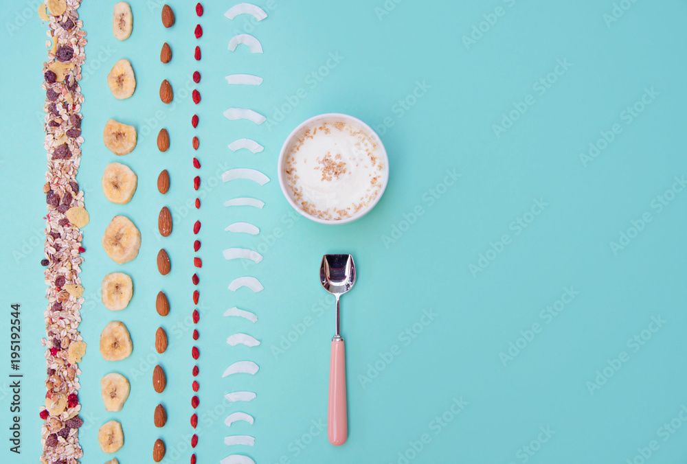 Naklejka premium Breakfast with berries and nuts on mint background, copy space.