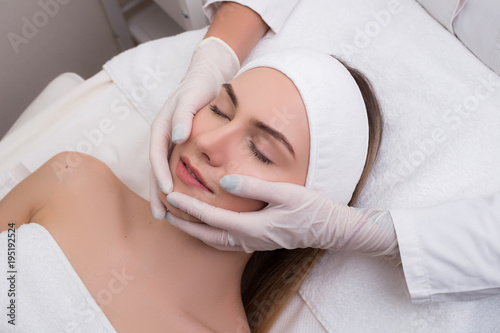 Keep your beauty! Good-looking youthful girl relaxing and having a massage procedure in the beauty SPA salon.