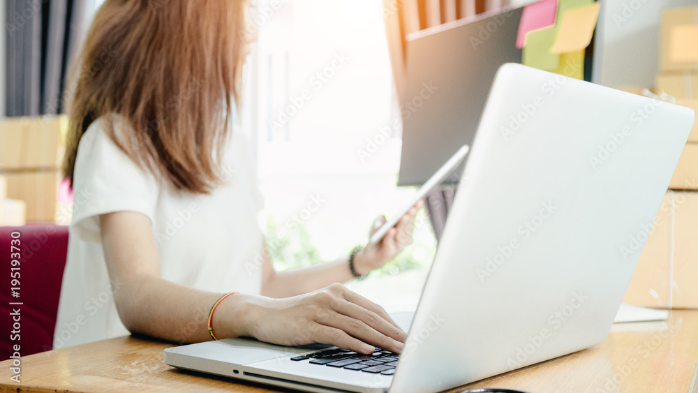 Fototapeta premium Young asian girl is freelancer with her private business at home office, working with laptop, coffee, online marketing, Customer order and packaging or packing.