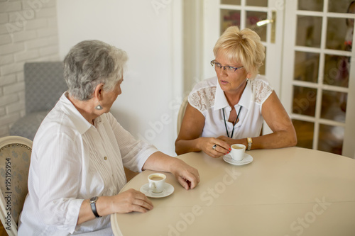 Two older women drinking co...