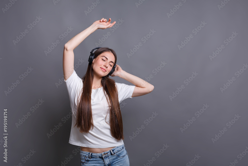 Woman with closed eyes enjoying music in earphones Woman with closed eyes enjoying music in earphones