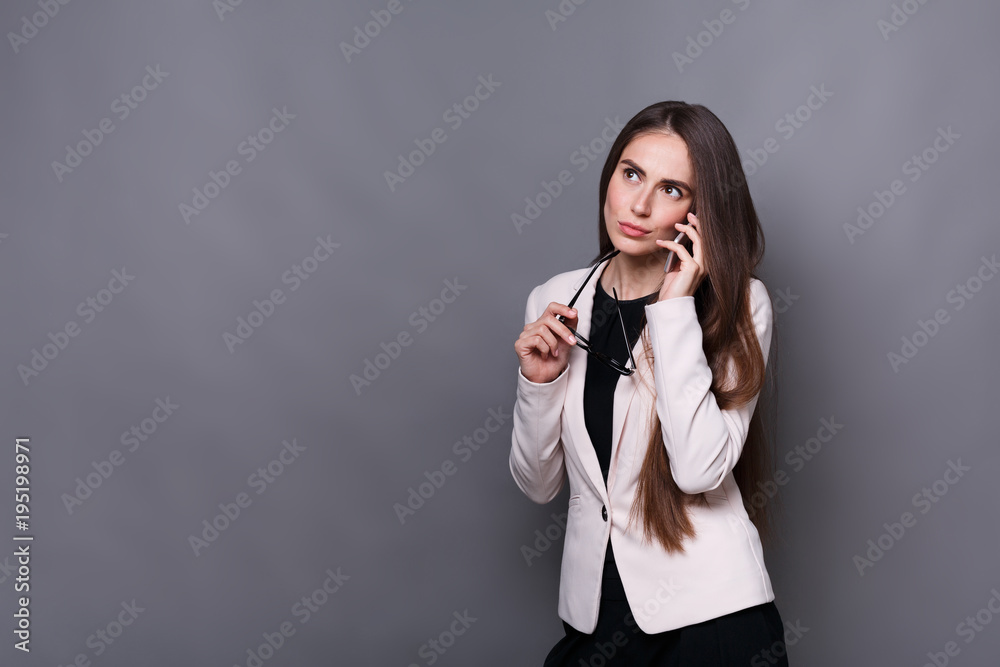 Pensive brunette business lady talking on cell phone Pensive brunette business lady talking on cell phone