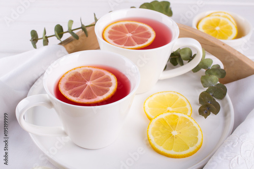 Two cups of red fruit and herbal tea with lemon slice, top view