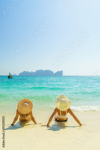 Fototapeta Naklejka Na Ścianę i Meble -  Two 2 young beautiful girls sunbathing on the tropical beach