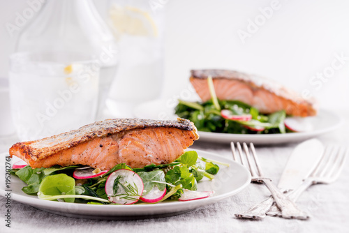 Roasted salmon fillets with spinach and radish salad.