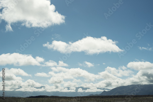 Paisaje montañoso con amplio cielo azul lleno de nubes