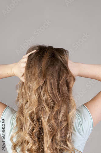 A young girl from the back with a strong headache. Convulsive spasm and headaches concept.