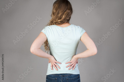 Woman with back pain holding her aching back - body pain