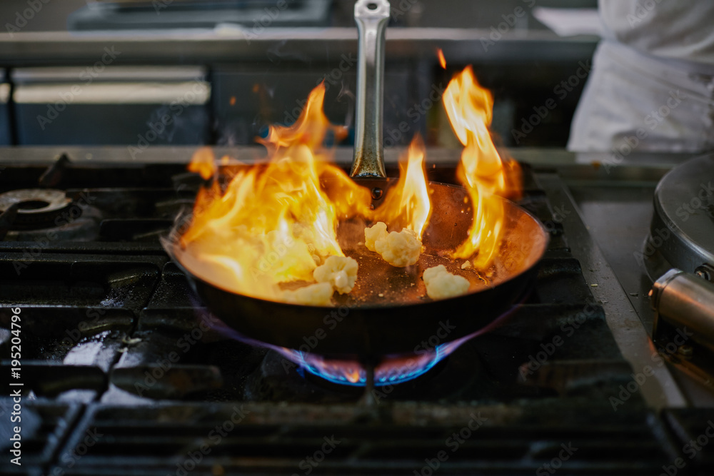 Close up of a frying pan with burning cauliflower Close up of a frying pan with burning cauliflower