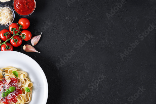 Ingredients for tagliatelle pasta on a dark background. Plate with pasta.