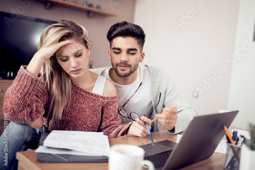 Young couple working together at home.
