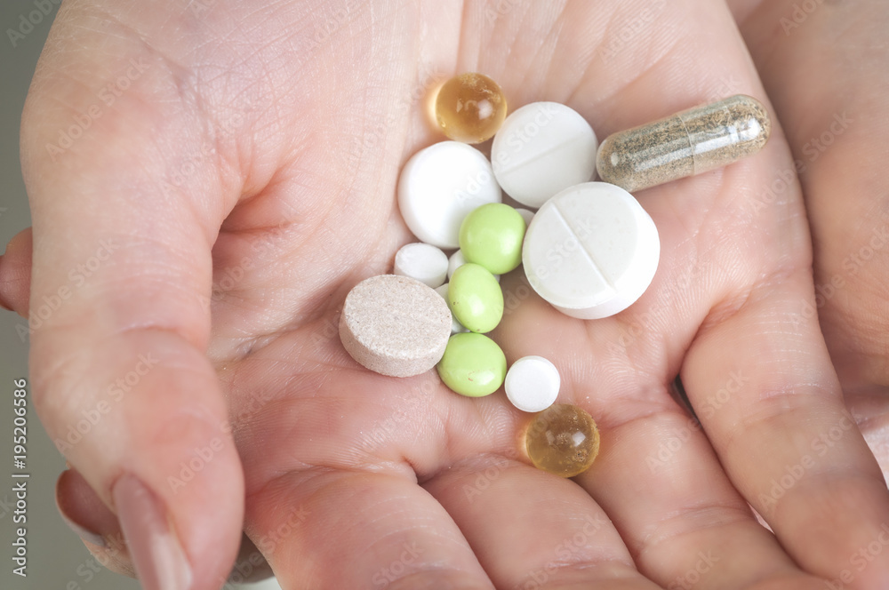 Multicolor pills in your palm, medications in woman's hand Multicolor pills in your palm, medications in woman's hand