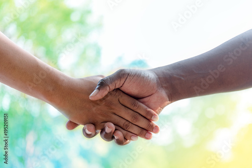 Close-up image of a firm handshake between two colleagues outside nature background,good relationship concept