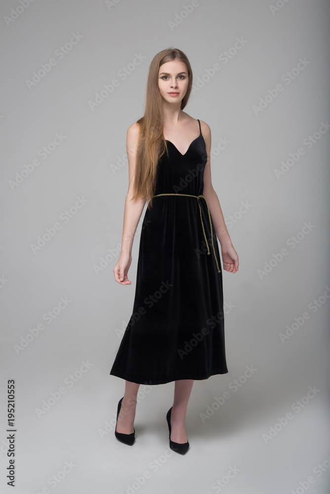 Young beautiful long-haired woman poses in long black dress Young beautiful long-haired woman poses in long black dress