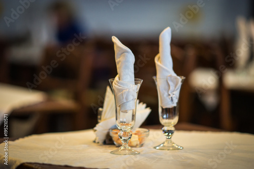 Wine glasses on a wooden table with white napkings photo