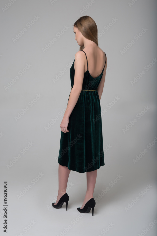 Young beautiful long-haired girl walks away in dark green dress Young beautiful long-haired girl walks away in dark green dress