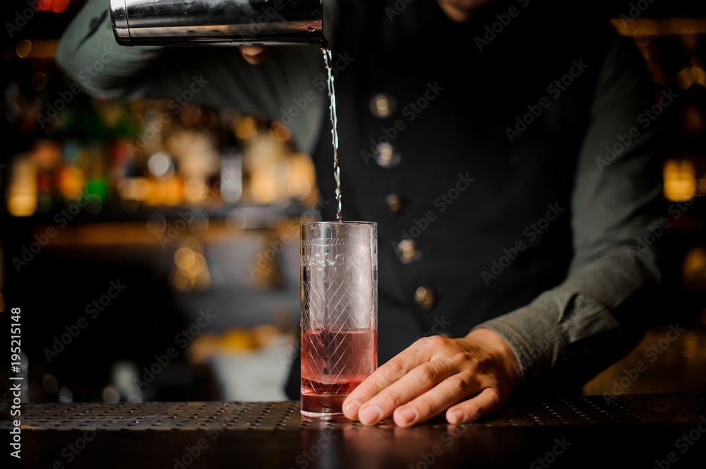 Bartender is making cocktail at the bar counter