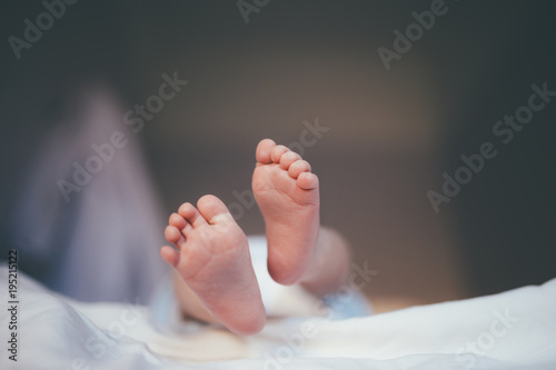 tiny feet of a newborn baby in focus during the diaper changes