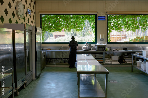 Lonely chef in his big kitchen at the begining of a long workday photo