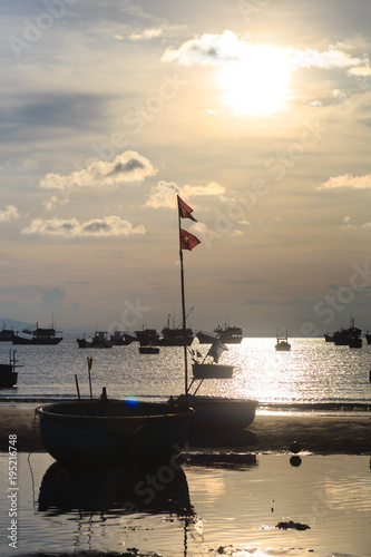 Vietnamese fishing boat silhouettes in sea at sunset photo