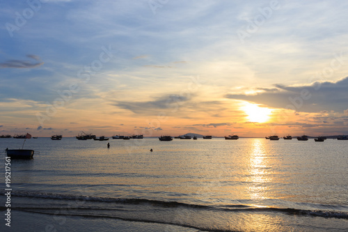 Vietnamese fishing boat silhouettes in sea at sunset