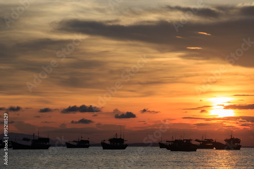 Vietnamese fishing boat silhouettes in sea at sunset