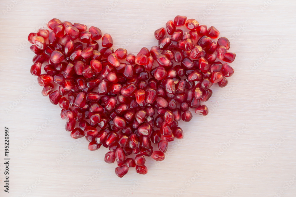 Heart made from grains of garnet on wooden table. Heart made from grains of garnet on wooden table.