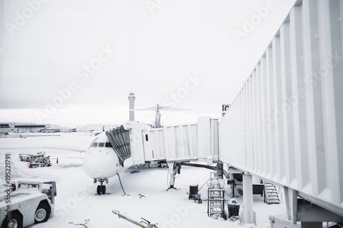 Airplane waiting at terminal with a snow covered ground photo