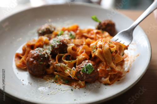 Spaghetti pasta with beef meatballs and tomato sauce on wood background . italian food