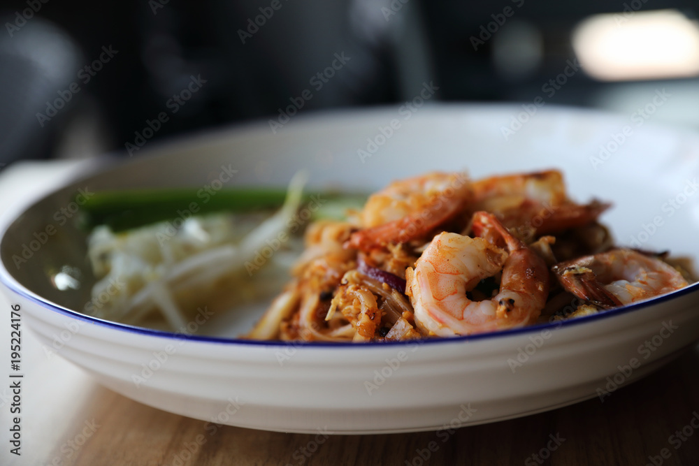 Pad thai with shrimp . Thai food on wood background