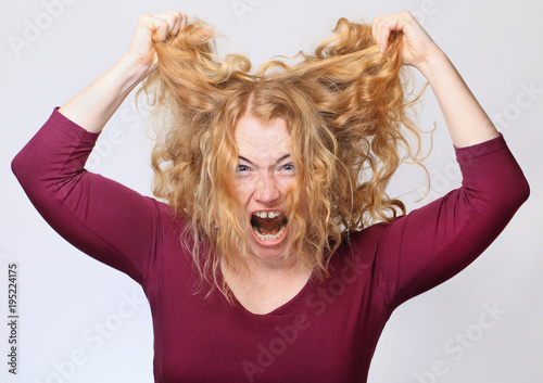 Woman screaming and keeping her hair up photo