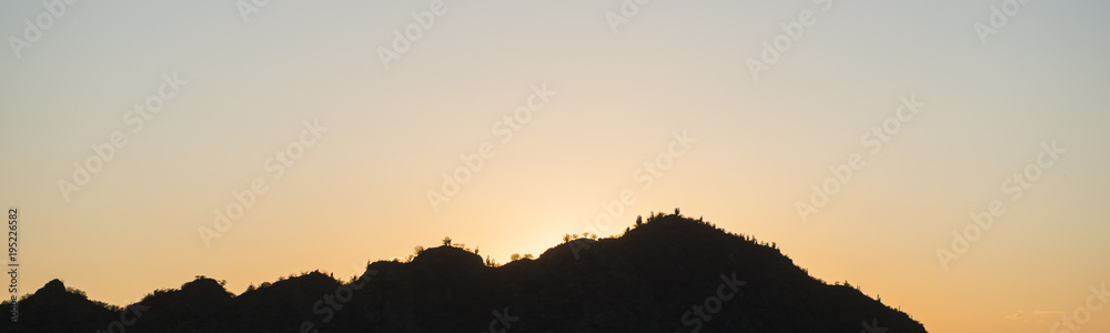 Naklejka premium panoramic landscape image of cactuss covered hills in Argentina at sunrise