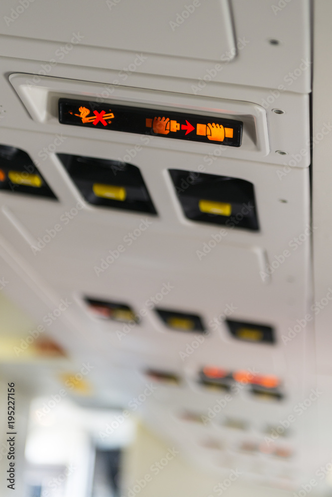backlit sign of fasten seatbelt seat belt and no smoking on an airplane