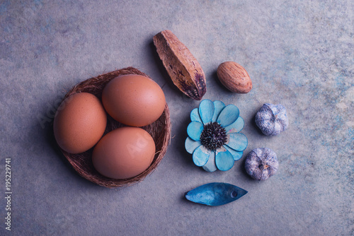 Big eggs inside the small nest and dry flowers as decor photo