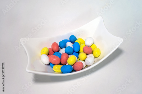 Konstfotografi Easter egg candy in sculptured white dish on white surface