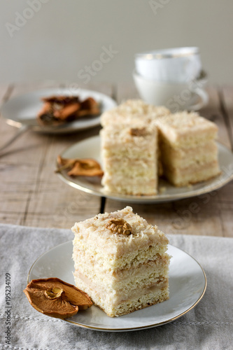 Pieces of apple cake and dried apples on a wooden table. Rustic style.