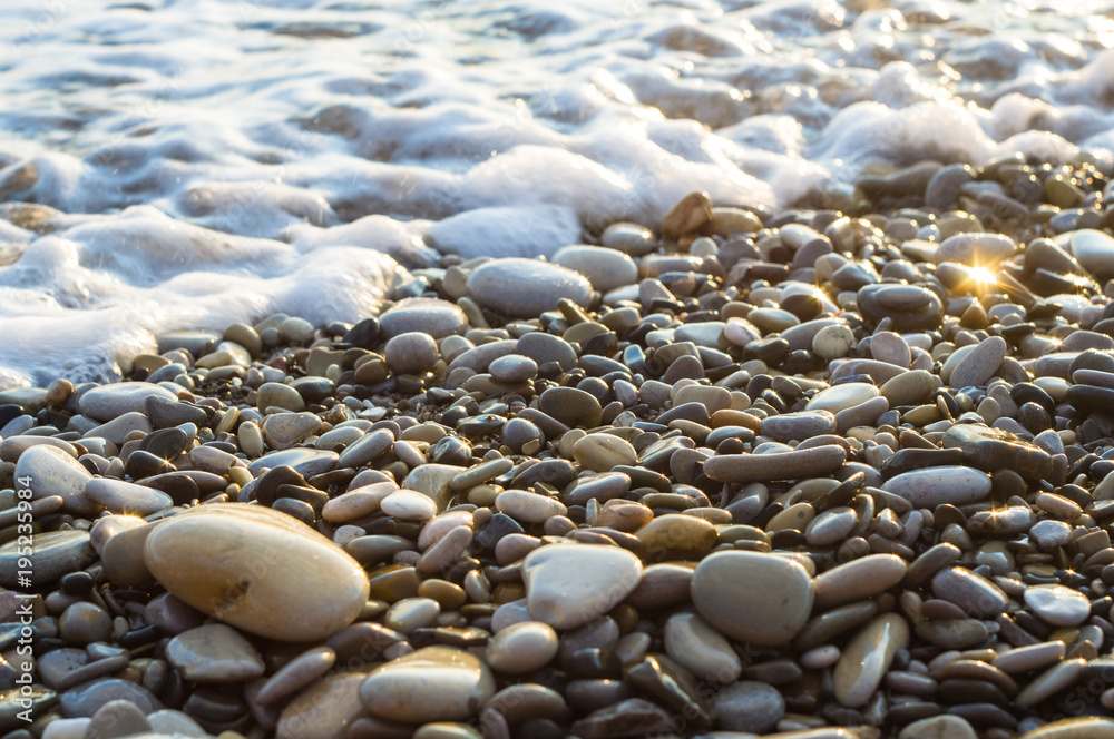 pebble stones on the sea beach, the rolling waves of the sea with foam pebble stones on the sea beach, the rolling waves of the sea with foam