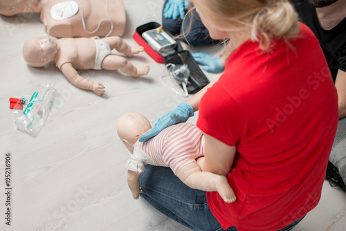 Εκτύπωση καμβά Instructor showing how to safe a life when the baby is choked sitting during the